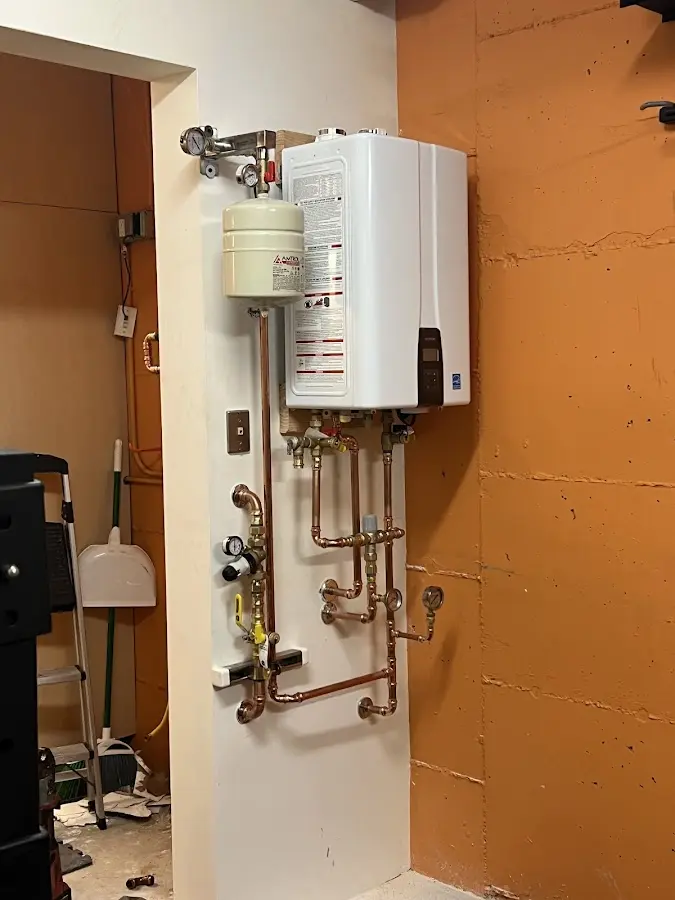 Plumbing technician inspecting water heater connections in Etowah
